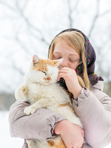 Vet smiling while holding a relaxed cat